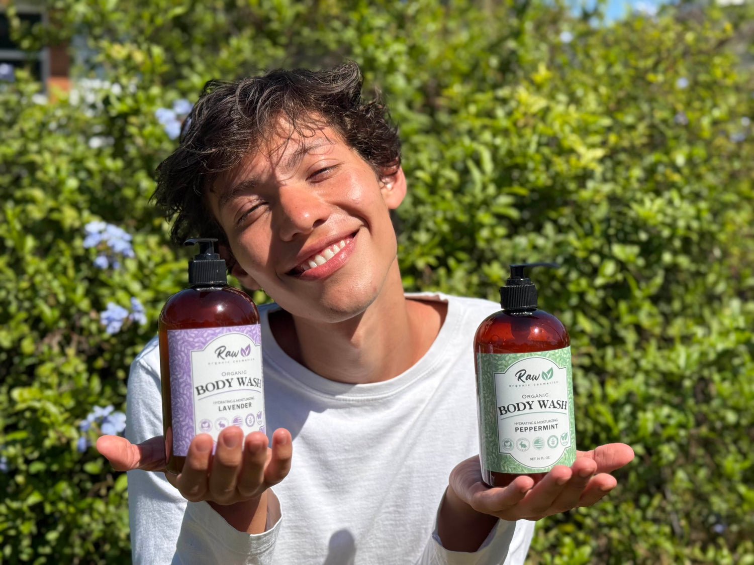 Man holding Raw Organic Cosmetics lavender and peppermint body wash with a scenic natural background, highlighting the organic and refreshing ingredients of the product.